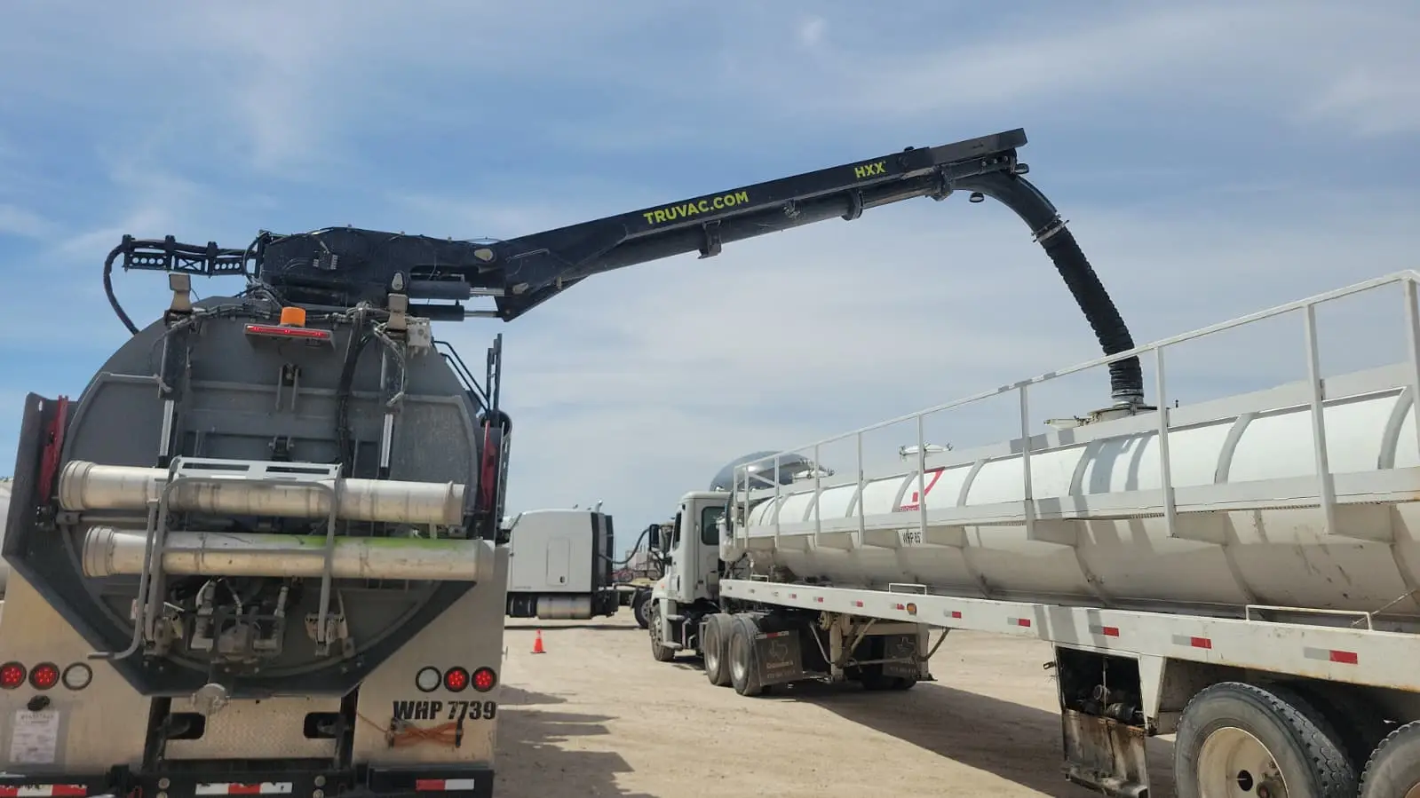 A Gentex boom reaching over and down into the top hatch of a tanker trailer, cleaning it from the access point with nobody inside