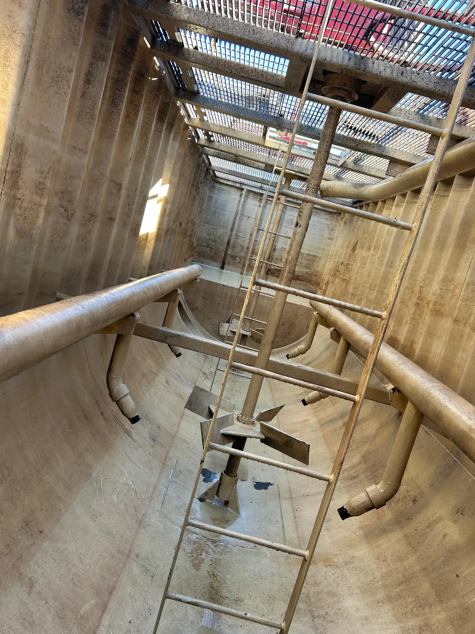 The same mixer after a Gentex cleaning: bare steel shell and floor, the agitator paddles and every internal pipe clean and visible