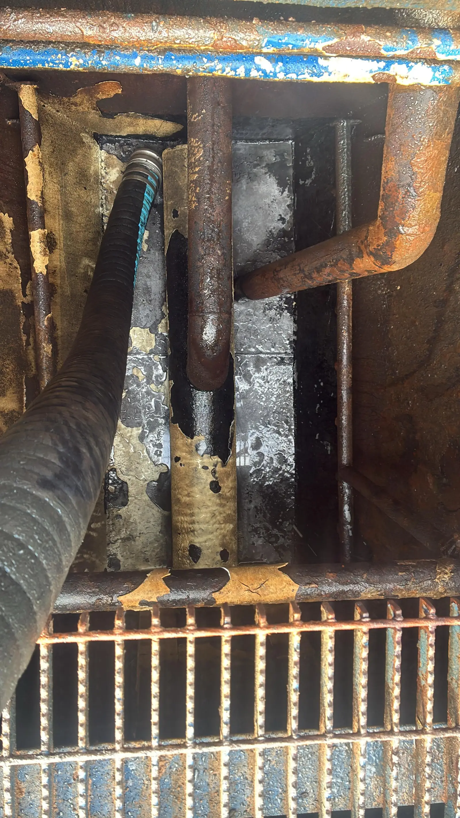 The same rig pit after a Gentex clean-out: floor, bracing and grating visible again with the sludge pumped out